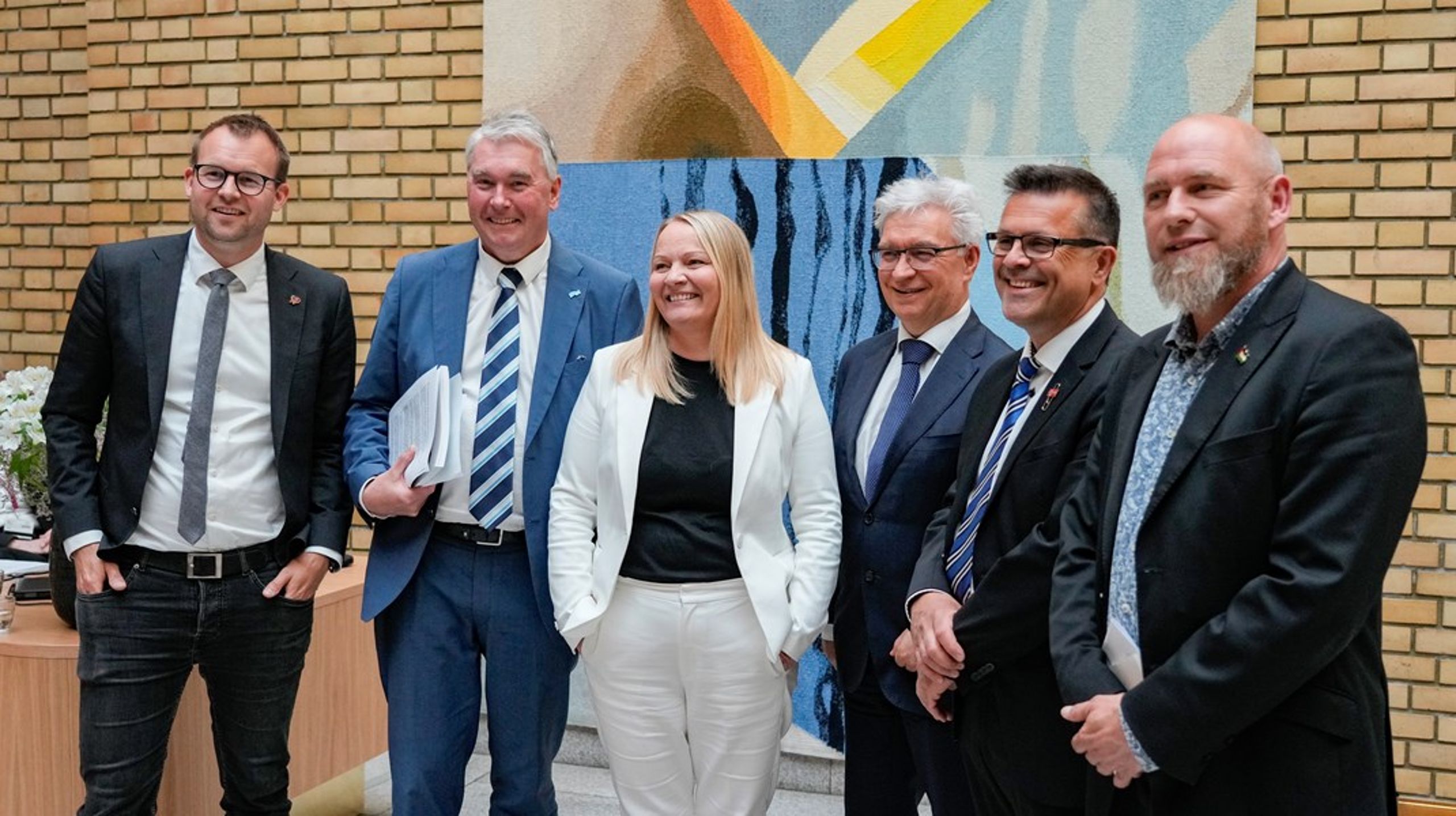 FORNØYDE: Trond Helleland (H), Mona Fagerås (SV), Frank Sve (Frp), Geir Jørgensen (R), Kjell Ingolf Ropstad (KrF) og André N. Skjelstad (V) i Vandrehallen i Stortinget, der de orienterer om enighet knyttet til prosjekter i forbindelse med Nasjonal transportplan 2025 - 2036. Foto: Terje Bendiksby / NTB