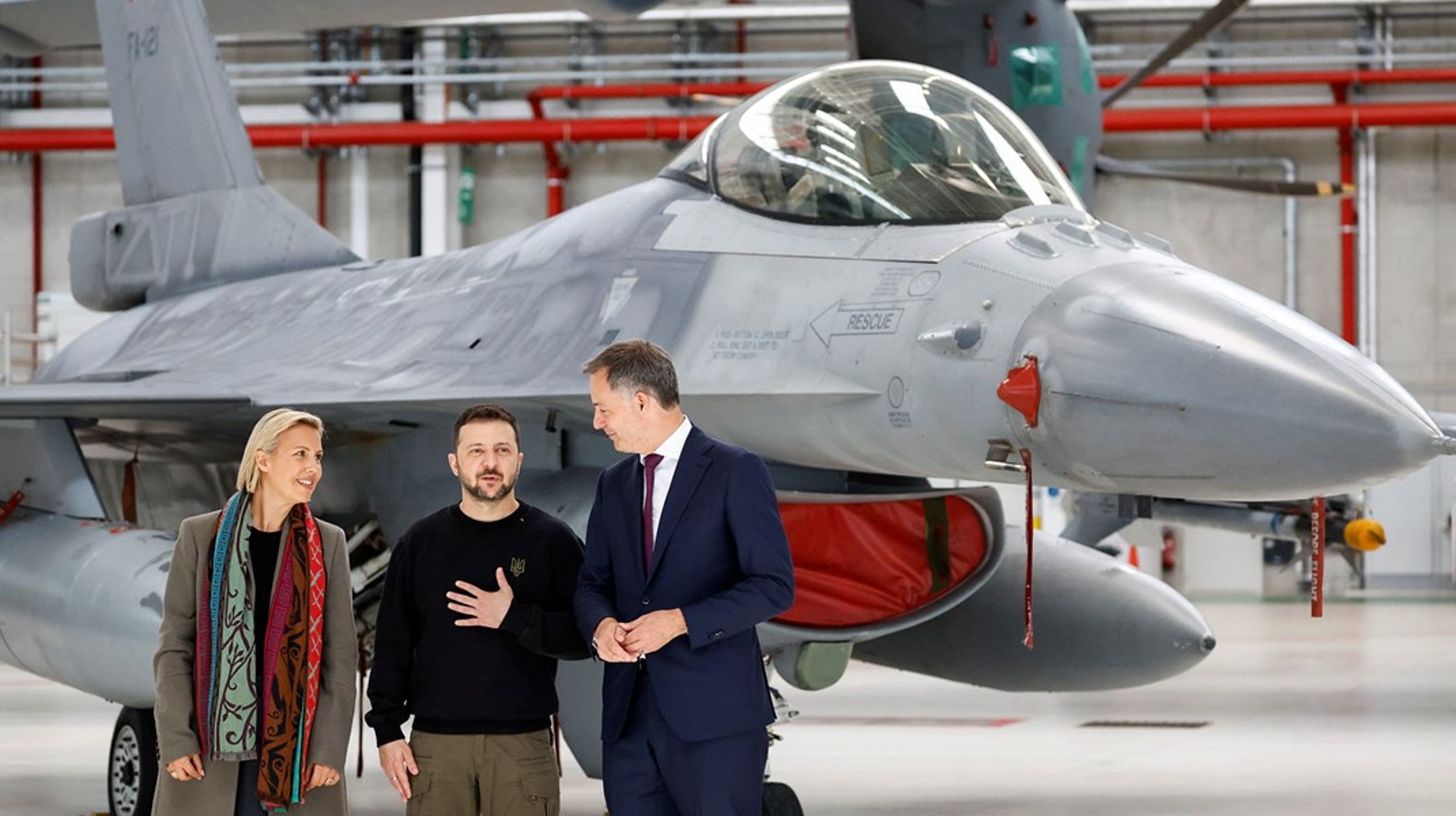 Ukraina-president Volodymyr Zelenskyj sammen med Belgias statsminister, Alexander De Croo, og forsvarsminister, Ludivine Dedonder, foran et F-16-fly i Belgia i mai.